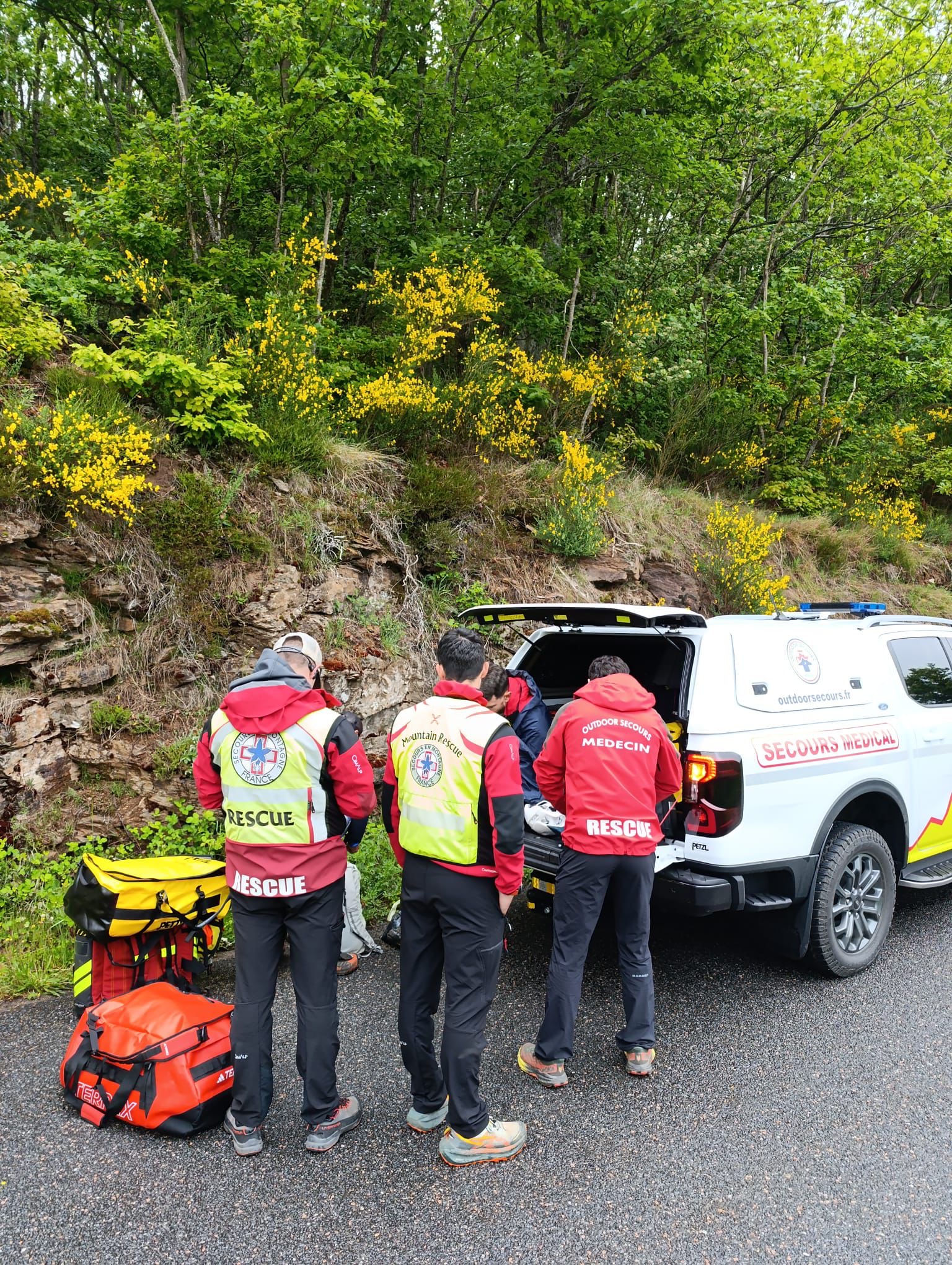 Équipe Outdoor Secours préparant les moyens au côté d’un véhicule médical